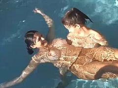 Wet sheer pantyhose cling tightly to the girls’ bodies as they float and stretch underwater in the sunny pool, the glossy nylon highlighting every curve while they tease and play together.